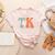 TK Teacher Retro Groovy Vintage Happy First Day Of School Women's Heather T-Shirt Heather Peach