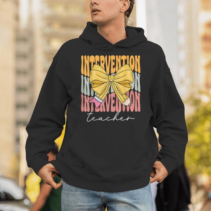 Interventionist Teacher Groovy Coquette Bow Back To School Unisex Hoodie, Groovy Teacher Hoodies, funny gift Interventionist Teacher Groovy Coquette Bow Back To School Unisex Hoodie, Groovy Teacher Hoodies, funny gift