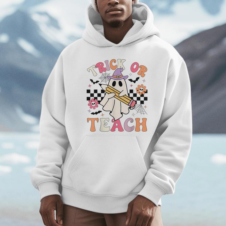 Trick Or Teach Groovy Teacher Halloween Retro Floral Ghost Unisex Hoodie, novelty gifts, funny gifts