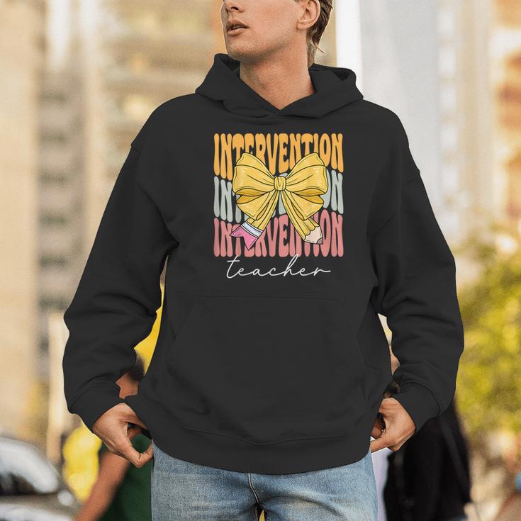 Interventionist Teacher Groovy Coquette Bow Back To School Men Hoodie, Groovy Teacher Hoodies, funny gift