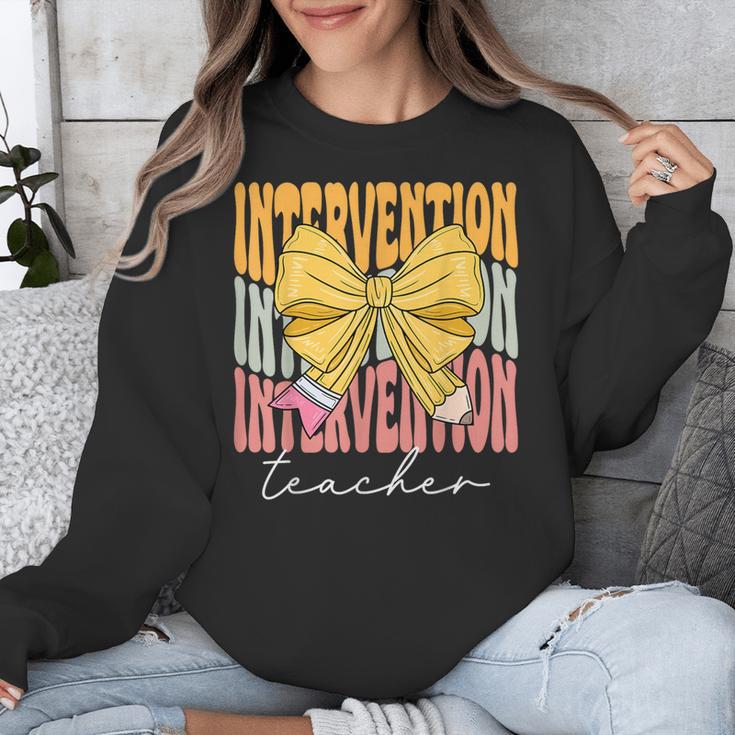 Interventionist Teacher Groovy Coquette Bow Back To School Unisex Sweatshirt, Groovy Teacher Gifts, funny design