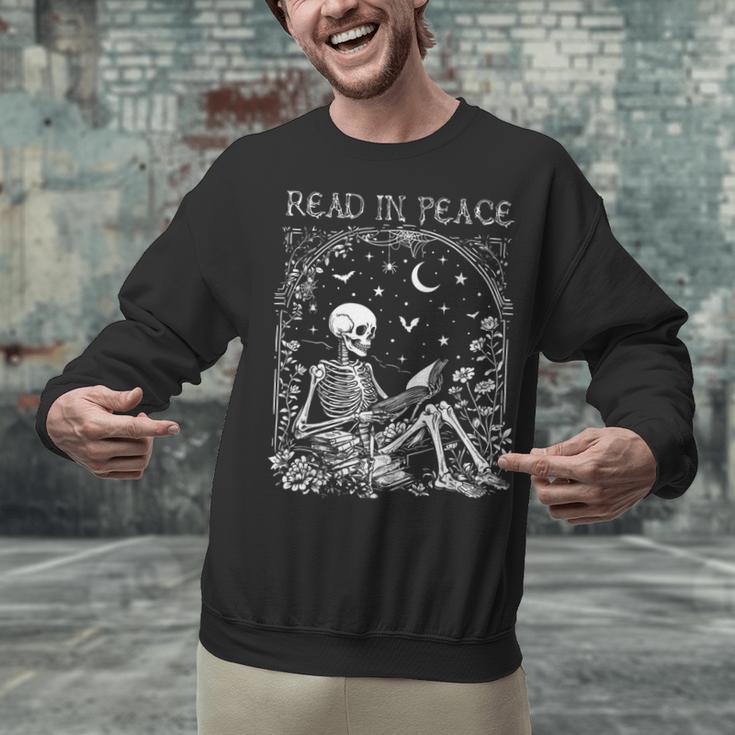 Read In Peace Skeleton Reading Teacher Spooky Halloween Unisex Sweatshirt, gift for family, gift for coworker Read In Peace Skeleton Reading Teacher Spooky Halloween Unisex Sweatshirt, gift for family, gift for coworker