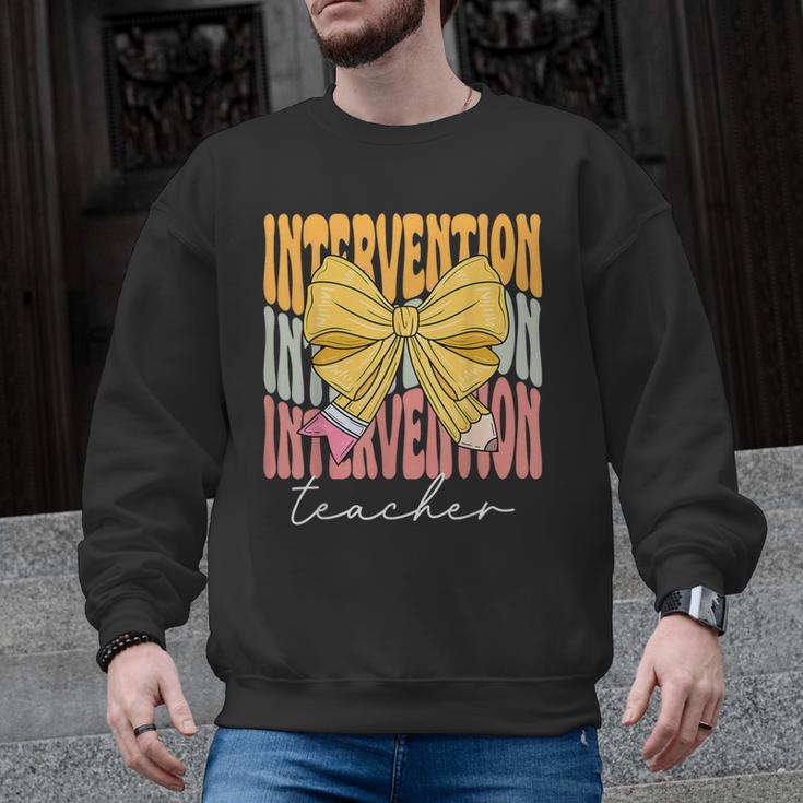 Interventionist Teacher Groovy Coquette Bow Back To School Men Graphic Sweatshirt